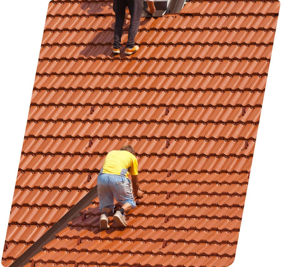 Two professional roofing contractors carefully aligning and anchoring individual interlocking orange clay shingles on a steep-slope tile roofing installation project.