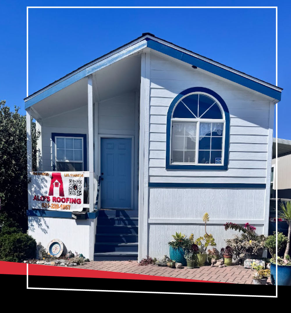 A white residential house with a blue trim roof completed by Alo’s Roofing Corporation, featuring a company banner on the front porch.